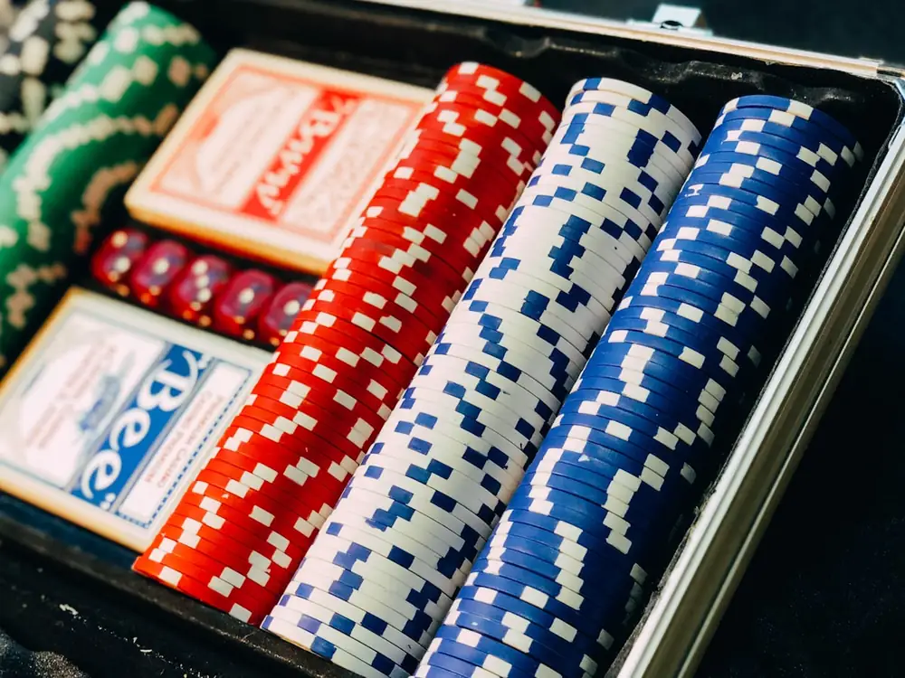 Susunan chip poker berwarna-warni di atas meja