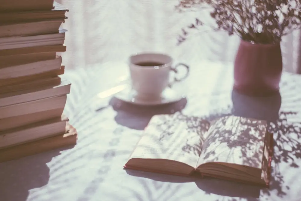 Buku terbuka di samping secangkir kopi